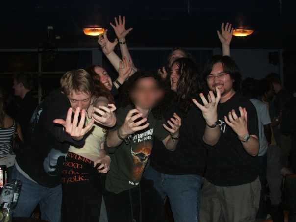 A group of young people posing comically in a student bar. At the time they were saying STEEEELLLL! and holding their hands out like claws. No, I don't remember why.